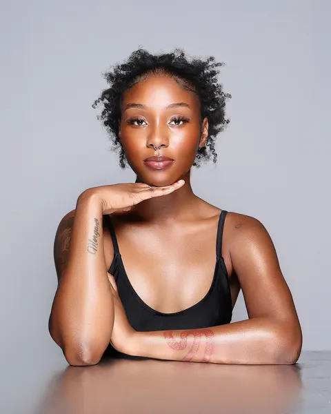 Retouched portrait with the tone and backdrop evened and the natural skin markings on the forearm kept untouched