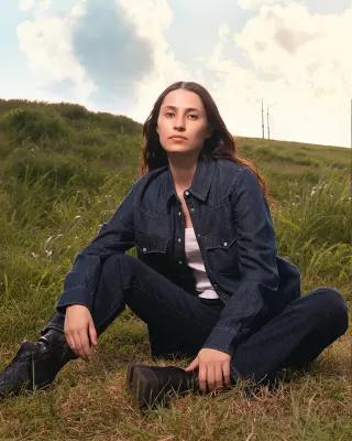 Retouched portrait with cloud detail recovered in the sky, the grass graded for depth and a warmer overall tone